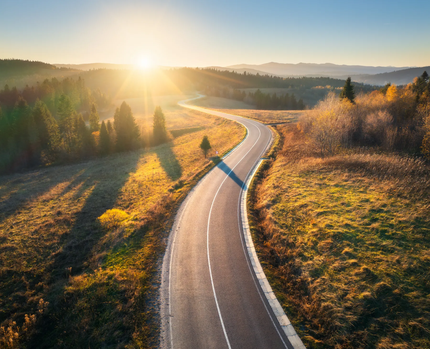 Winding road at sunset golden hour